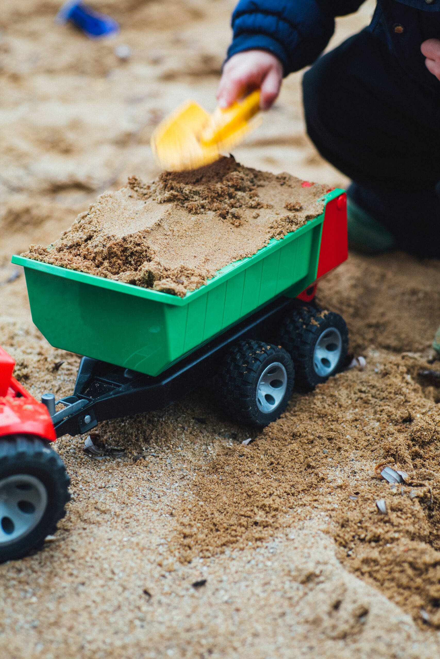 Un enfant joue avec un jouet de camion sur la plage